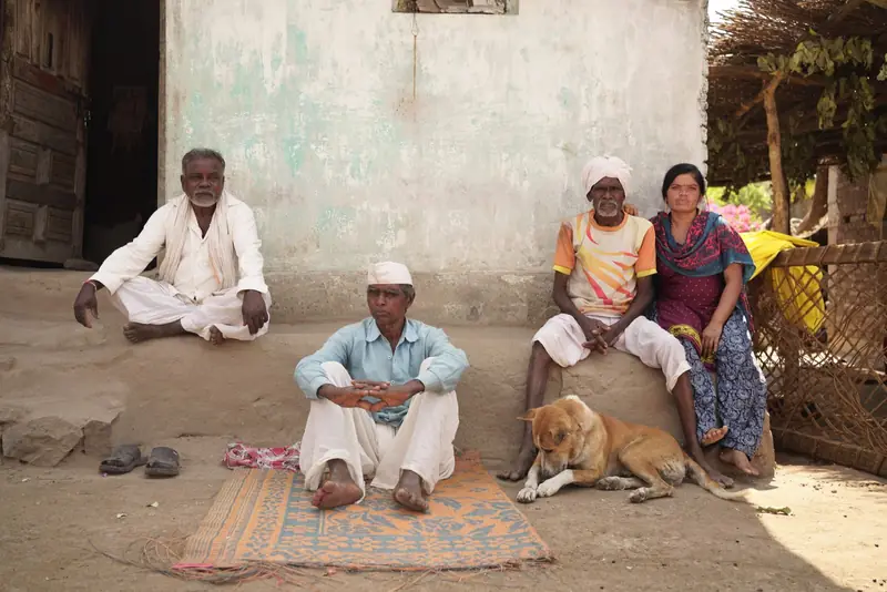 A family sitting outside their home in a village