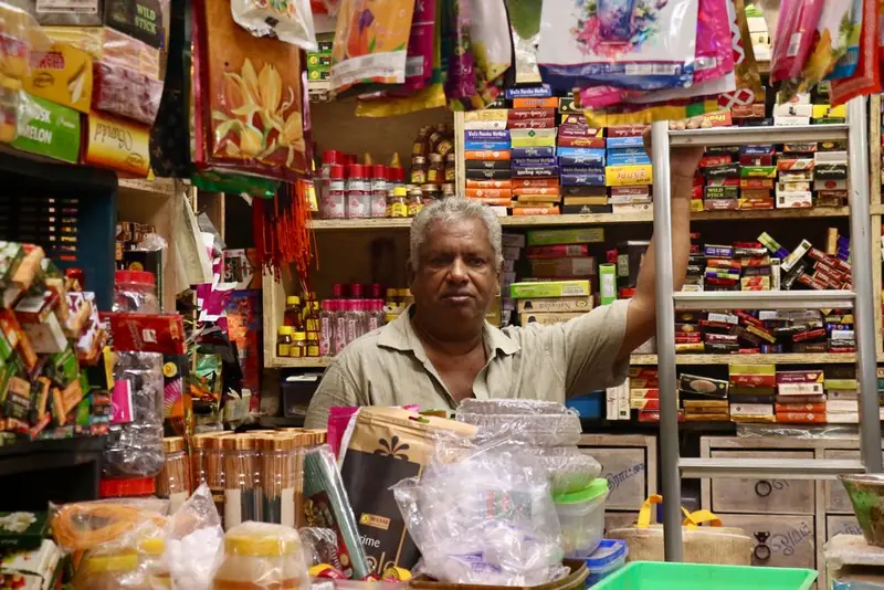 A shopkeeper working in a busy grocery store