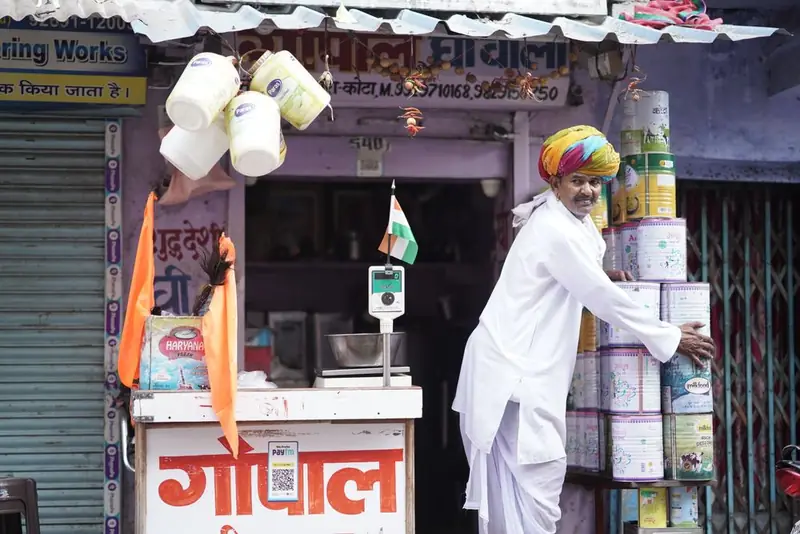 A merchant arranging goods outside his shop in Kota, Rajasthan