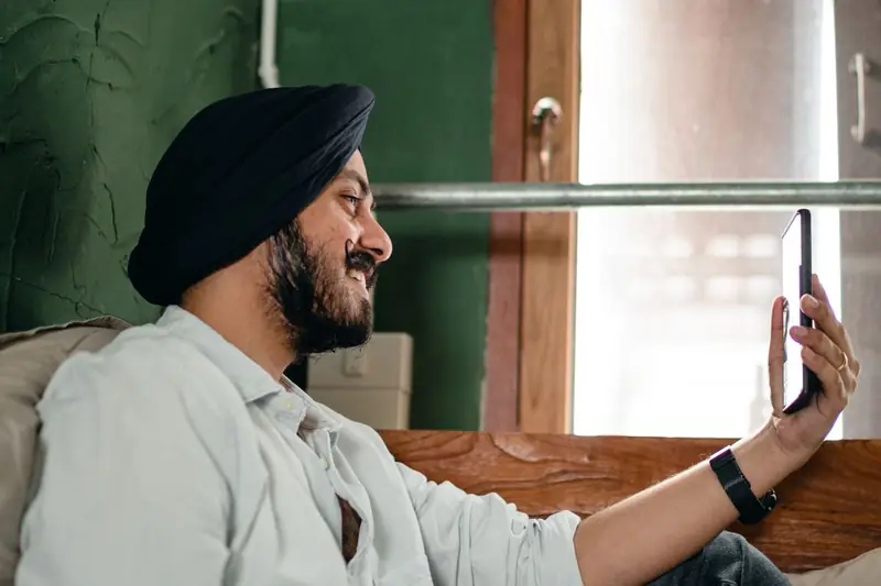 A young man smiling while talking on his phone